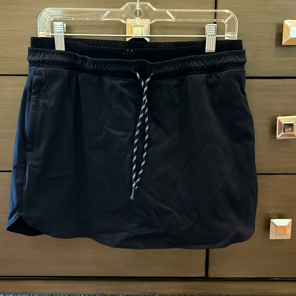 Athleta Navy Skort sz 8. Two front zipper pockets, Stretch waist. Length is 14”